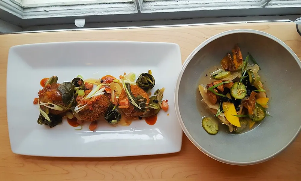 Delicious plated dish featuring vegetables and crispy fried items on a wooden table.