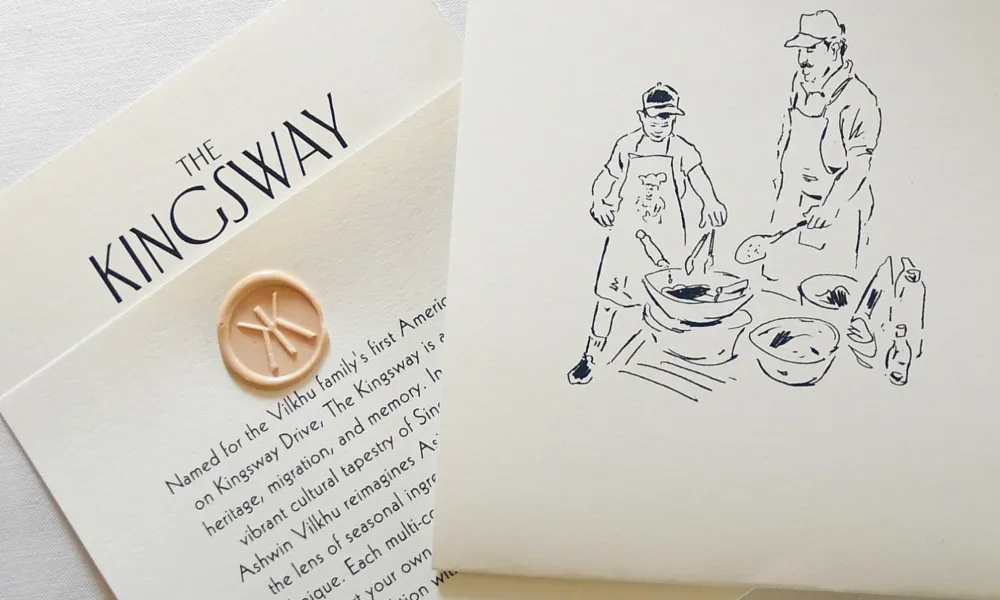 The Kingsway card with a wax seal and a sketch of two people cooking together on cream paper.