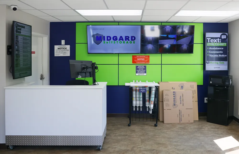 a room with a green board and white tables and a cart