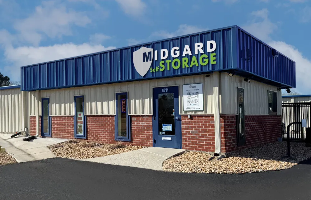 Midgard Self Storage building with blue and beige exterior under a partly cloudy sky at entrance.