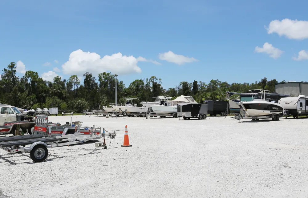 a group of trailers parked in a sandy area with trees in the background