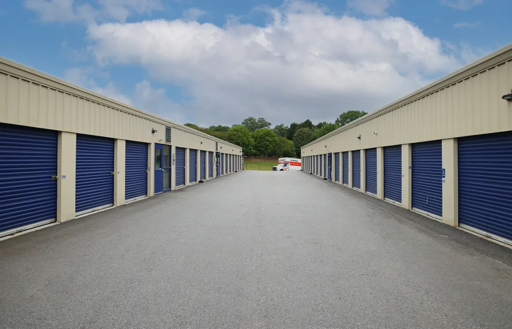 a road with a row of garages and a car parked on the side