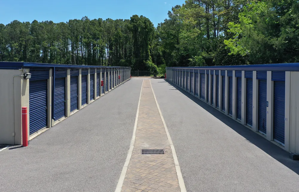 a row of blue metal fenced off area with trees in the background