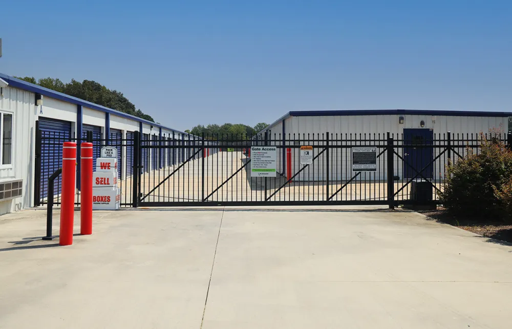 a gated off area with a sign and a building in the background