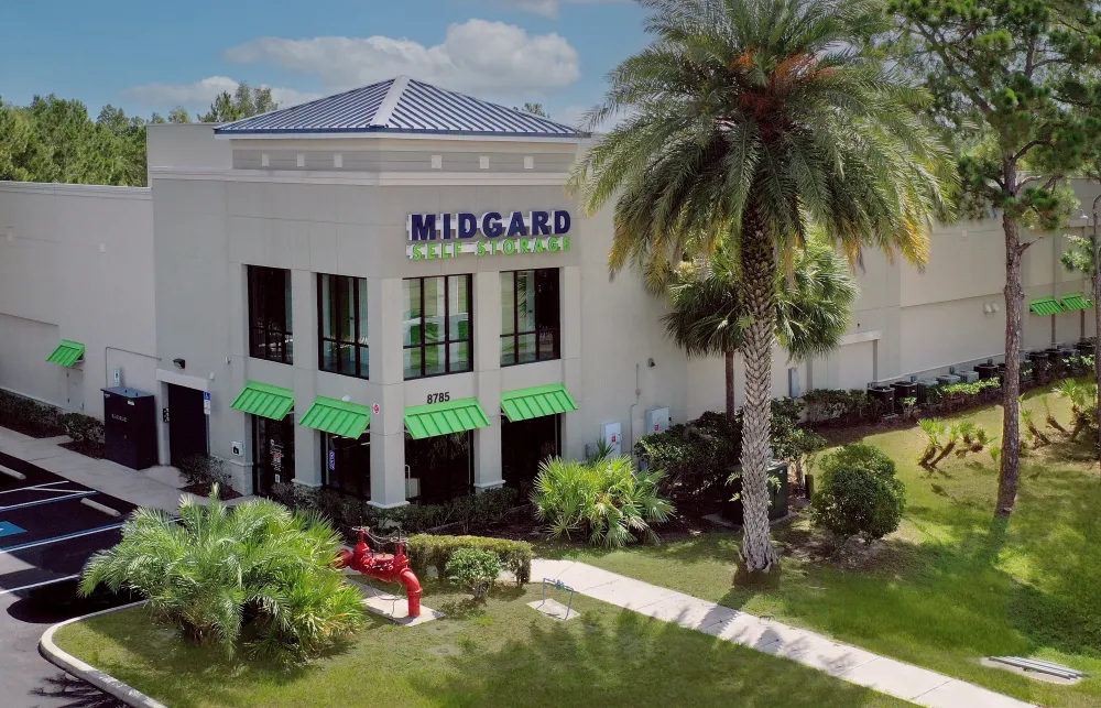 a building with palm trees and a lawn