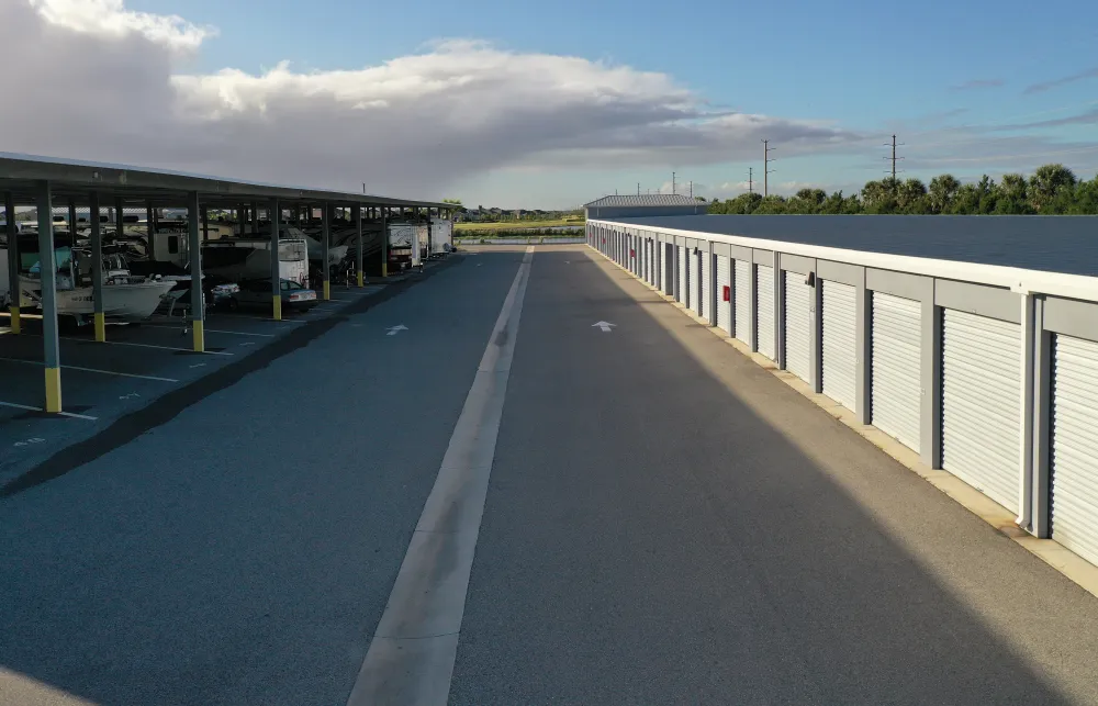 a road with a white fence and a white building with a blue sky