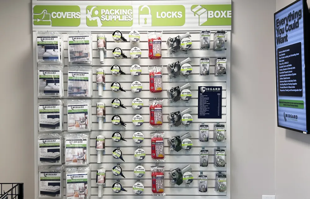 Retail wall display of covers, packing supplies, locks, and boxes organized by type and brand.