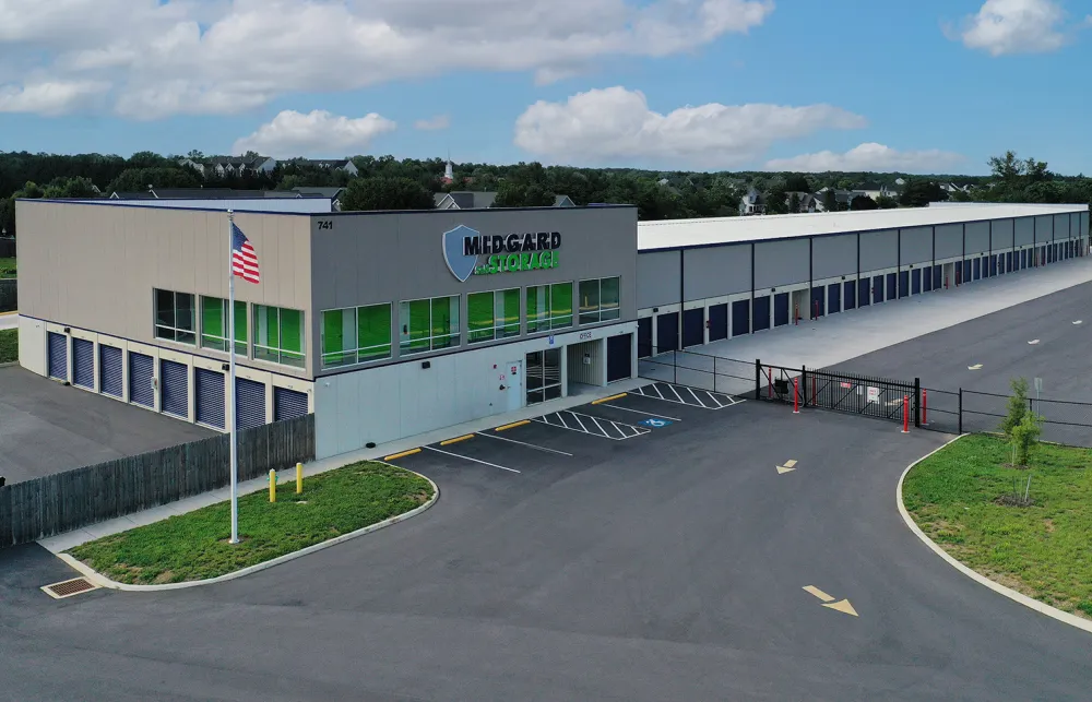 Modern Medgard Self Storage facility with multiple storage units and office building under blue sky