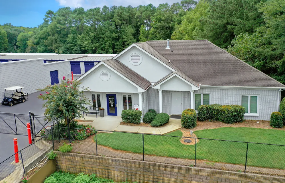 a house with a lawn and a fence in front of it