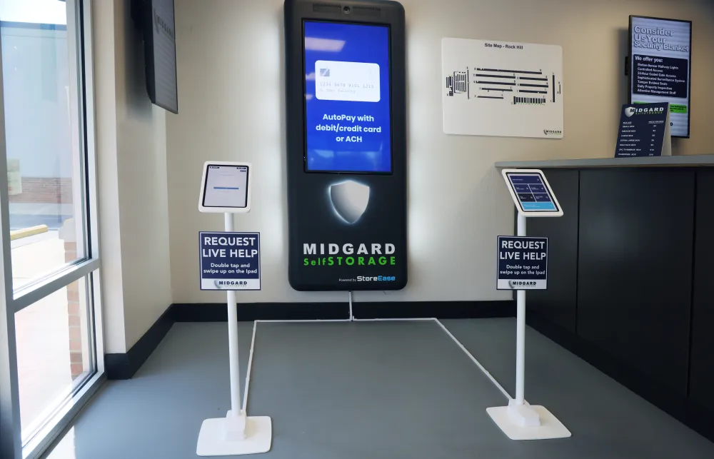 Interactive Midgard Self Storage kiosk with auto-pay and live help iPads in a bright lobby corner.