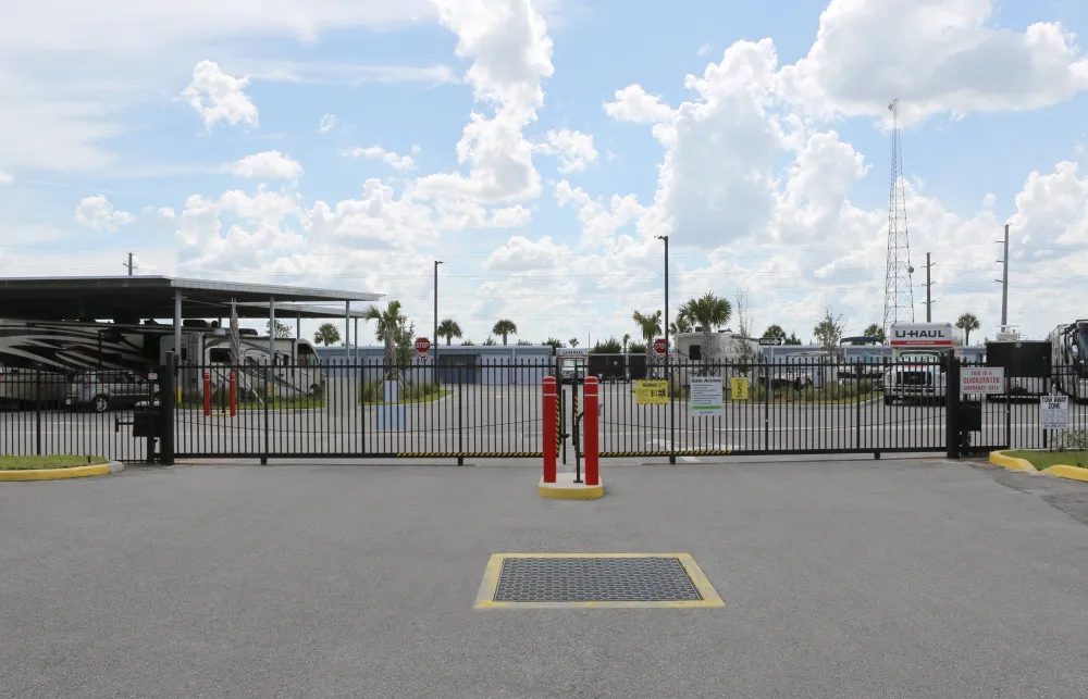 a parking lot with a fence and a building in the background