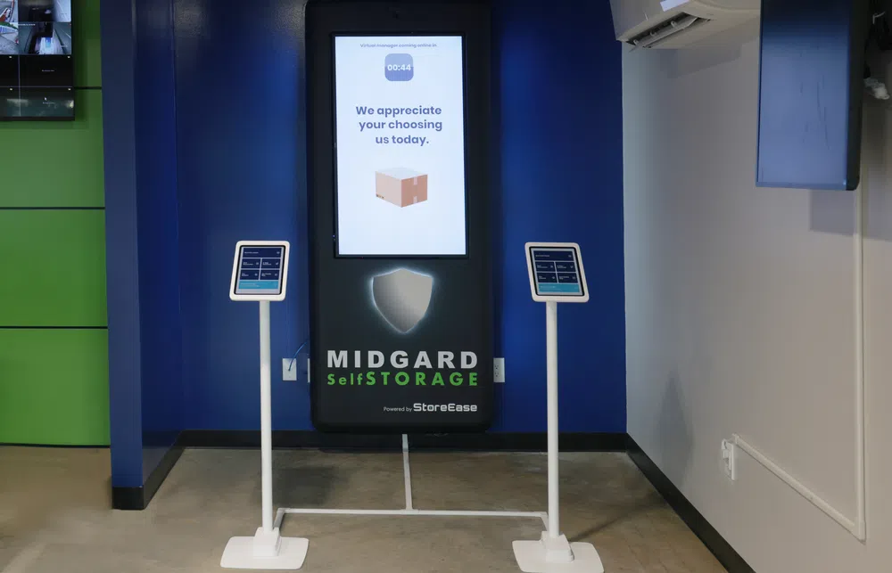 Midgard Self Storage digital kiosk with touchscreen stands in a modern storage facility lobby.