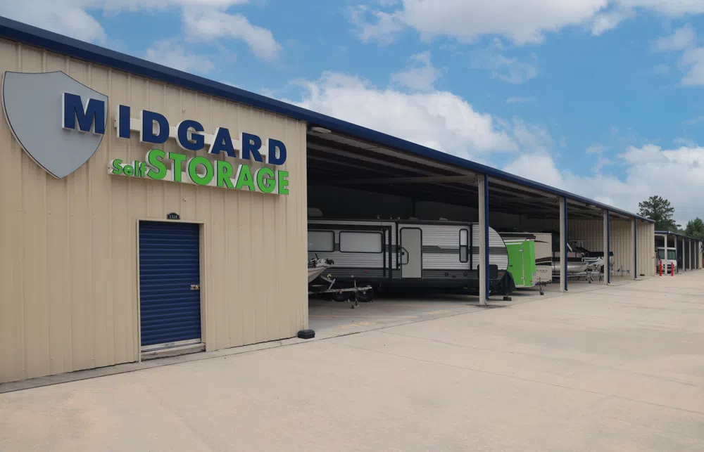 Midgard Self Storage facility shows covered storage units with RVs and boats under a partly cloudy sky.
