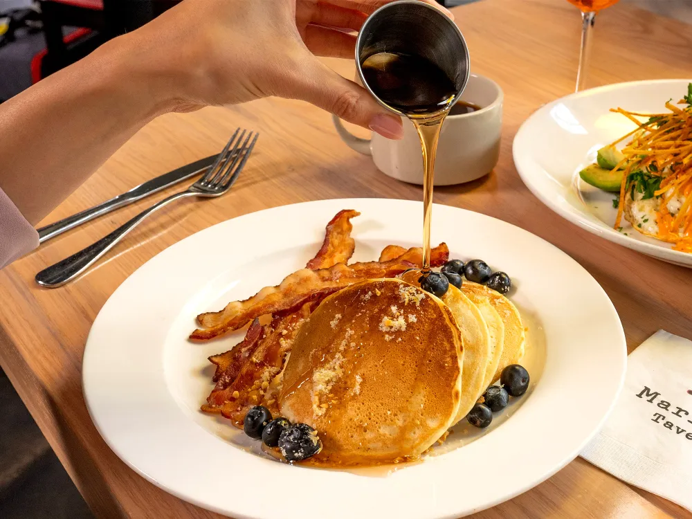 Spicy chicken wings with ranch dip, carrot sticks, celery, grilled flatbreads, and loaded nachos in trays.