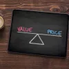 A tablet displaying a balance between value and price, with coffee on a wooden table.