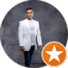 Man in white blazer and dark pants standing against a gray textured background with an orange star icon overlay.