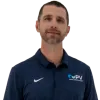 Man wearing navy blue PV Heating Cooling Plumbing polo, beige pants, brown belt, and brown shoes standing relaxed.