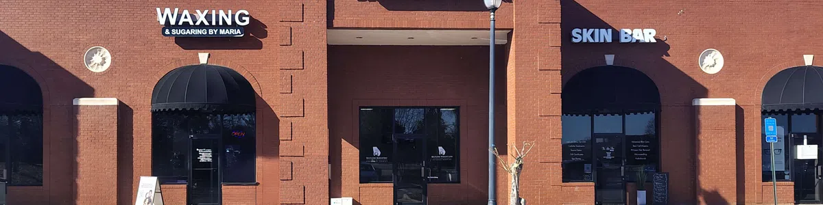 Brick storefronts of Beltline Bariatric, Waxing by Maria, and Skin Bar under a clear blue sky
