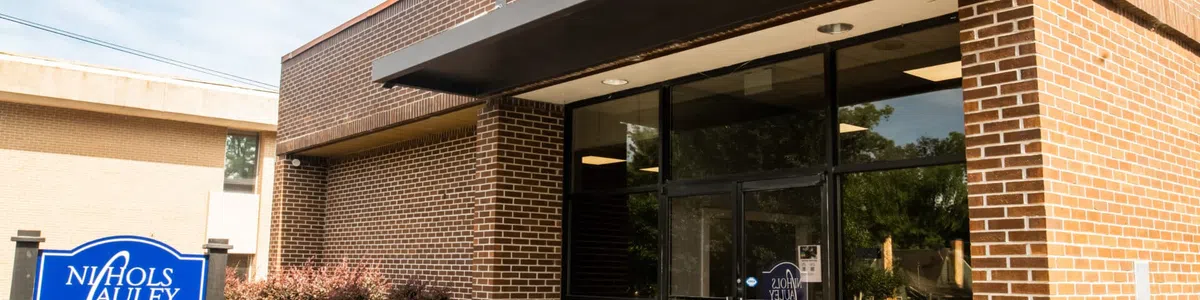 Entrance of Nichols Cauley Certified Public Accountants office with brick exterior and blue signage.