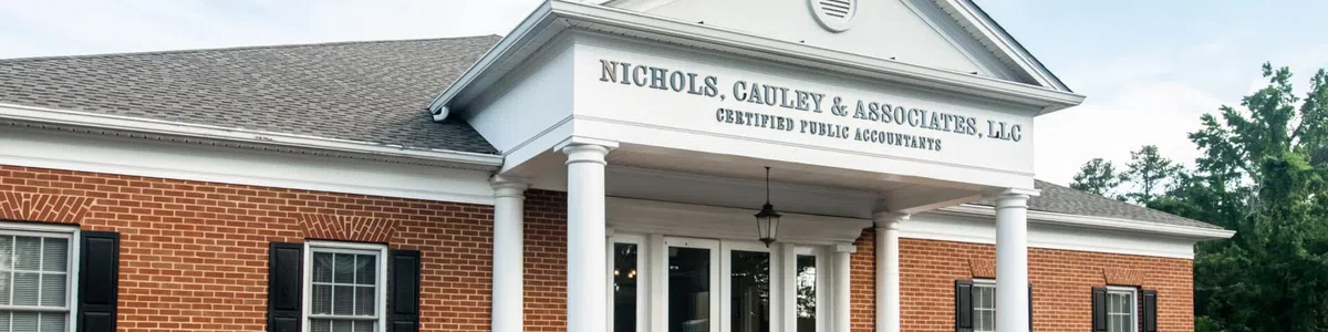 Brick office building with white columns and sign reading Nichols, Cauley & Associates, LLC Certified Public Accountants.