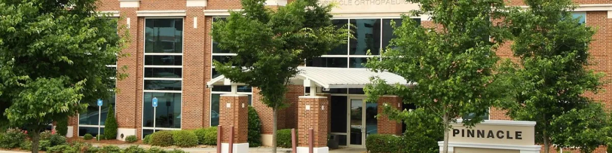 Exterior view of Pinnacle Orthopaedics and Sports Medicine clinic with brick facade and greenery