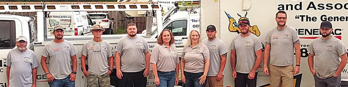 Team of professionals from Forrest and Associates posing in front of company vehicles.