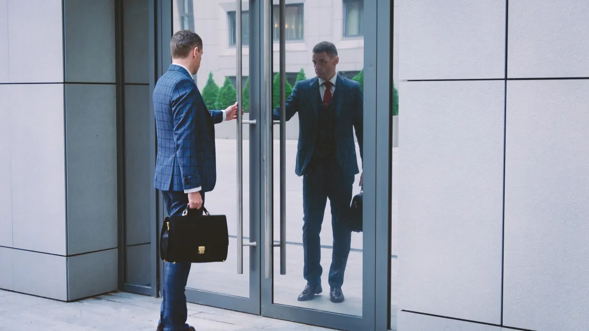 men in suits standing in a doorway