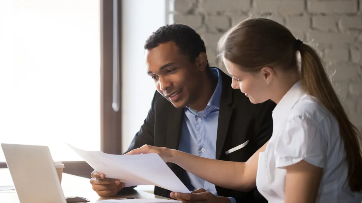 a man and a woman looking at a laptop