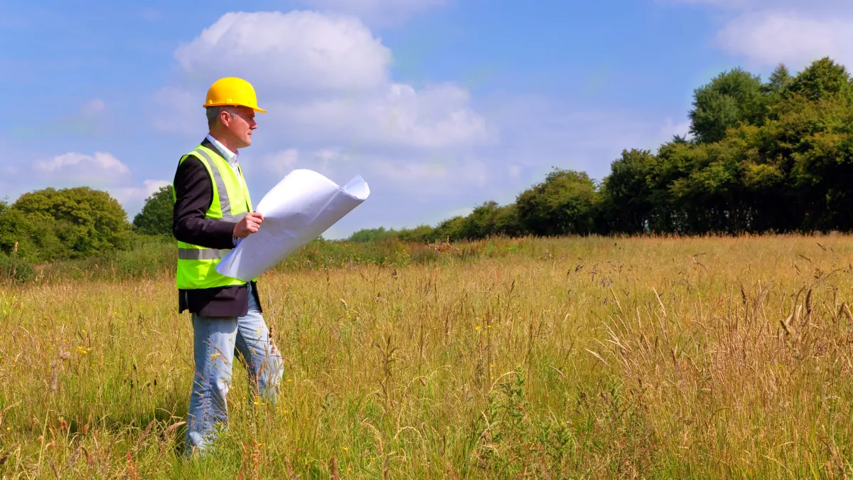 a man holding a white object in a field