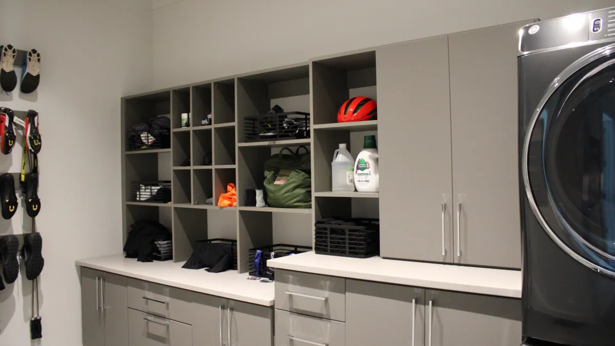 a laundry room with grey cabinets