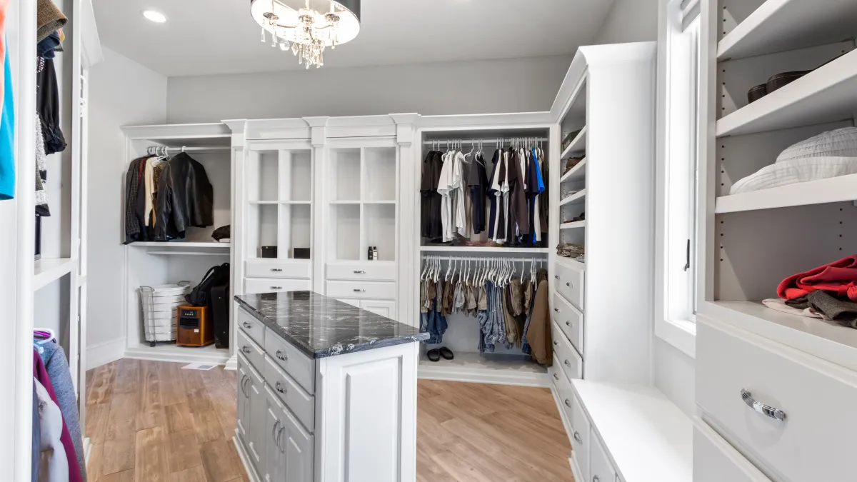 a closet with white cabinets and white shelves