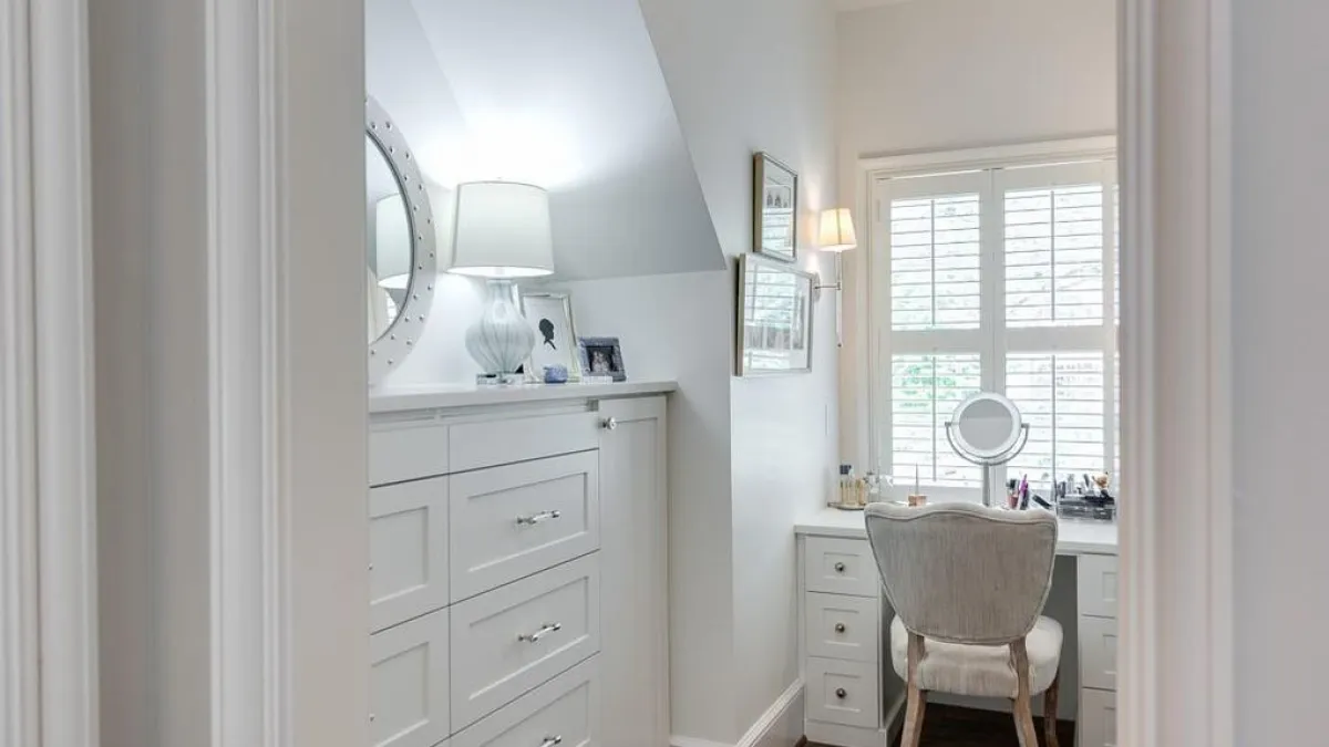 a white room with a chair and a dresser