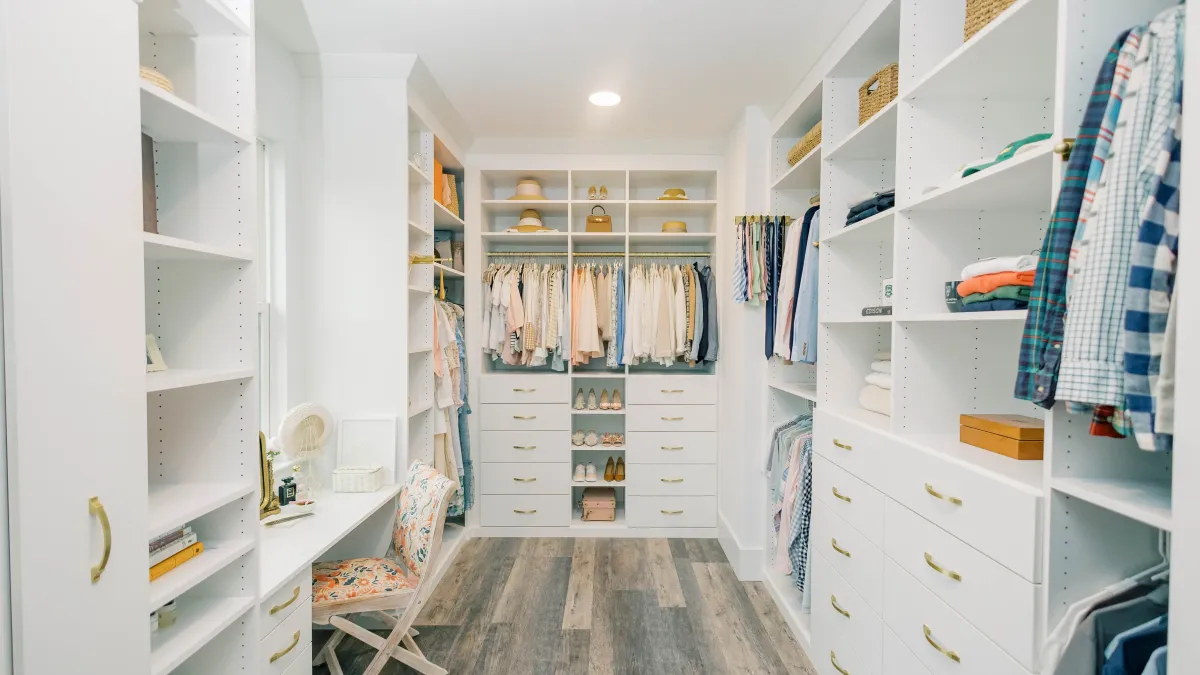 a room with white shelves and a chair