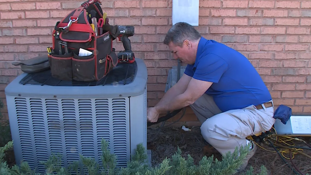 Bardi technician inspecting an outdoor AC system for replacement
