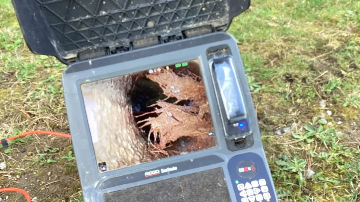 Sewer video camera showing roots in a sewer pipe.
