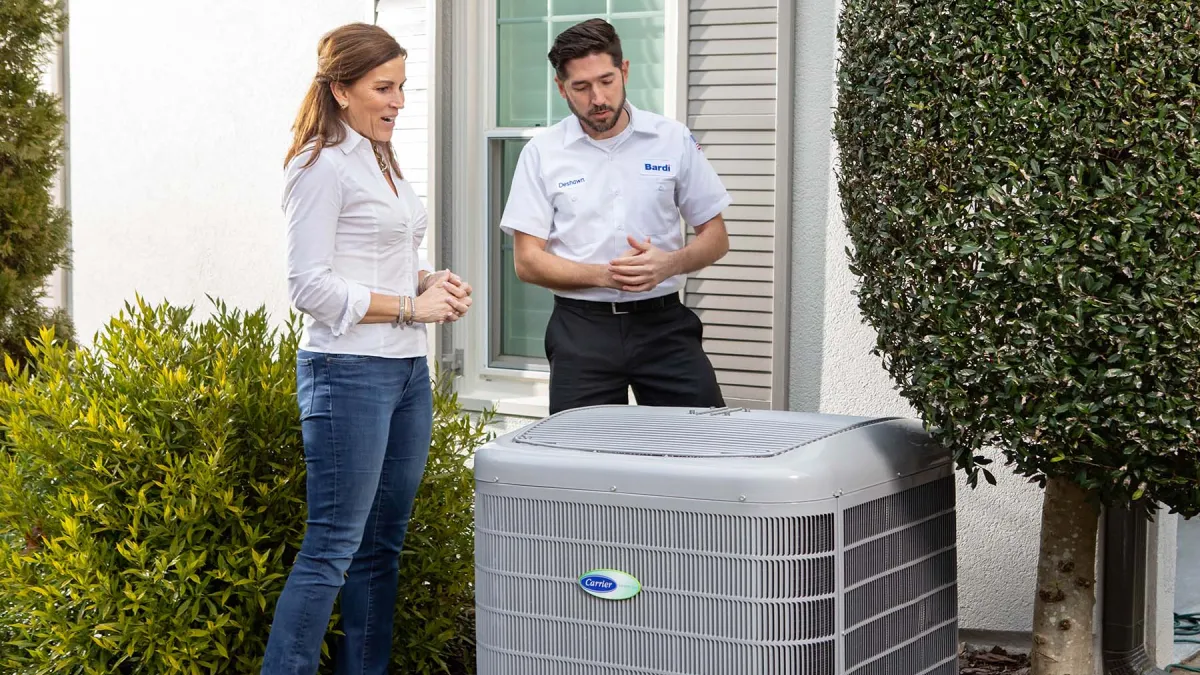 Homeowner consulting with technician about energy-efficient HVAC unit installation.