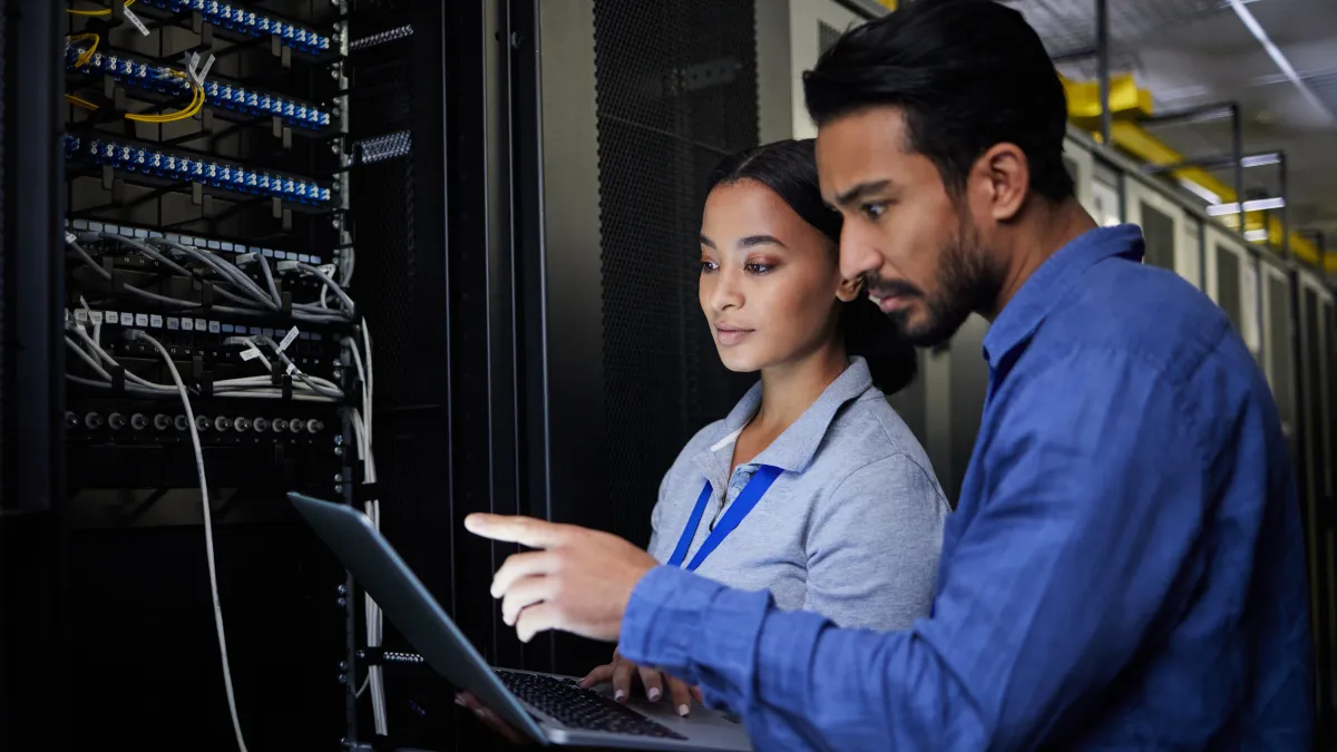 a man and a woman looking at a laptop