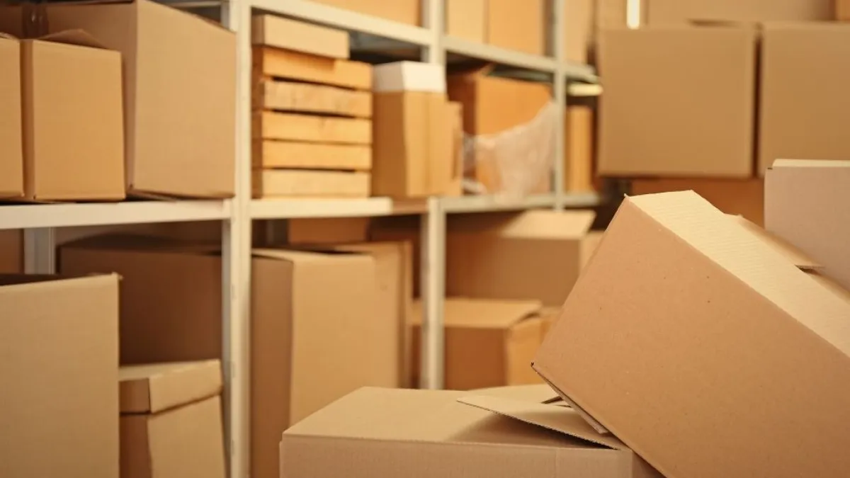 Shelves filled with various sizes of stacked brown cardboard boxes in a storage room or warehouse.
