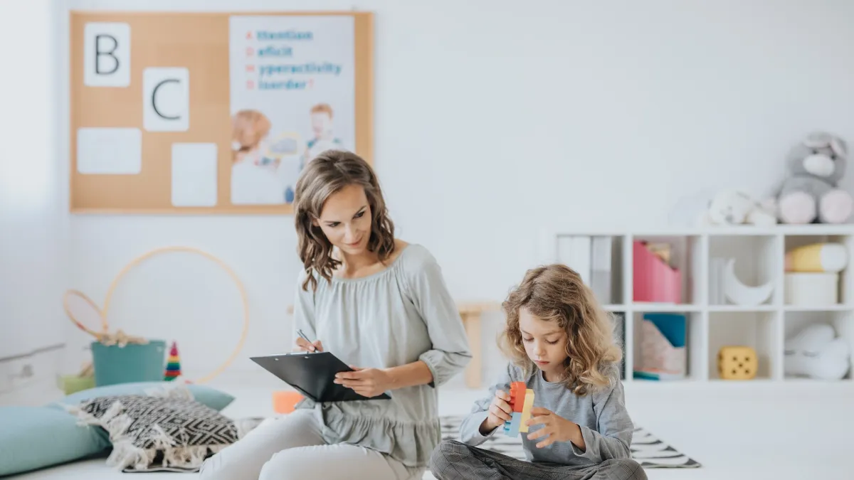 a teacher and an autistic child doing ABA therapy in Johns Creek, GA