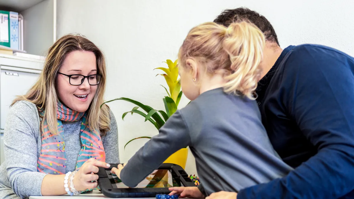 a woman showing a woman something on the computer