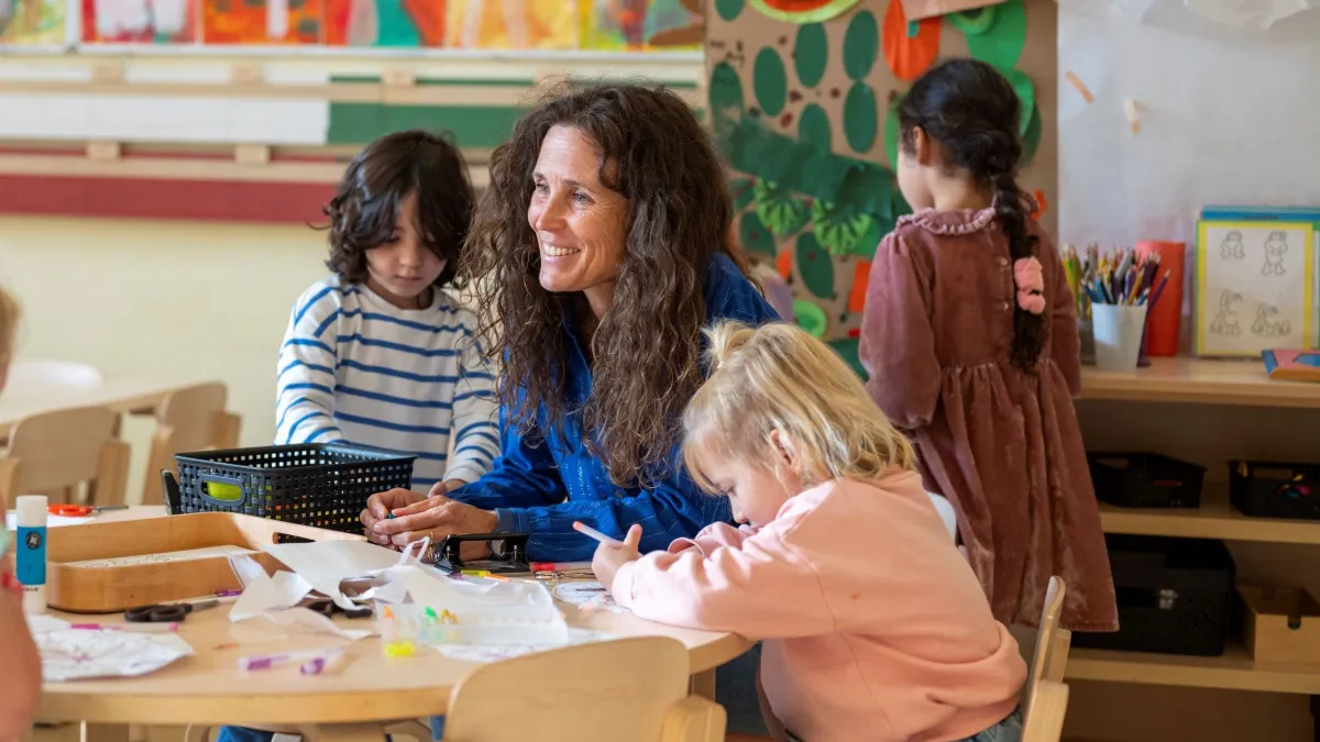 a teacher helping her autistic students