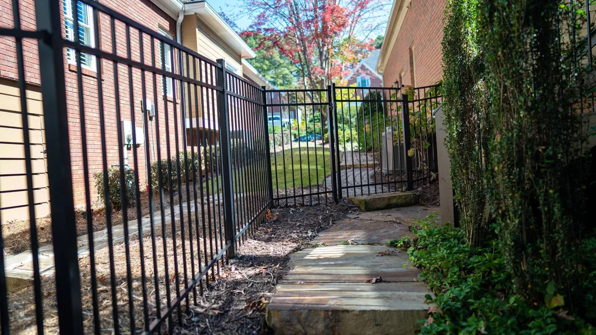 a gated yard with a bench