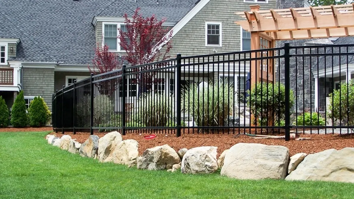 a fenced in yard with a house in the background