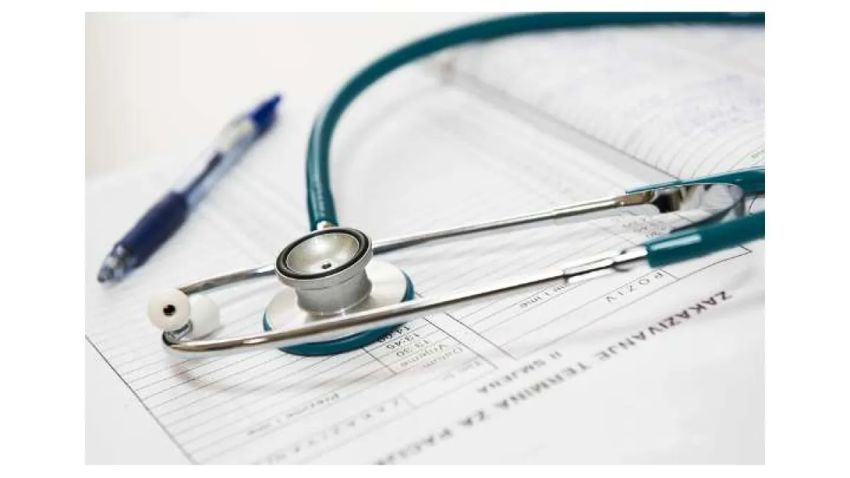 Stethoscope and pen placed on a medical form representing healthcare and patient records.