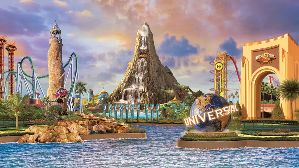 Universal Studios theme park entrance with Volcano Bay, roller coasters, water, and iconic globe at sunset.