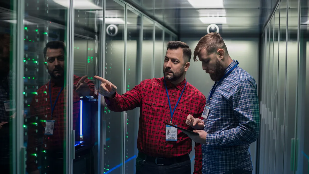 a group of men standing in a room with glass walls