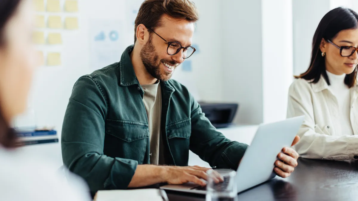 a man and a woman looking at a laptop