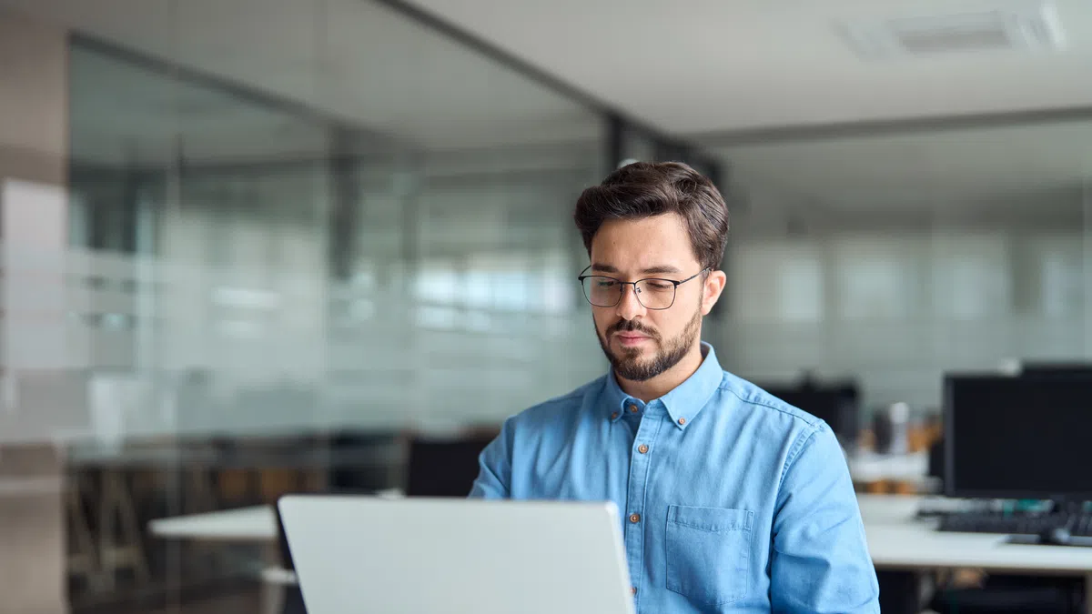 a man sitting at a desk with a laptop