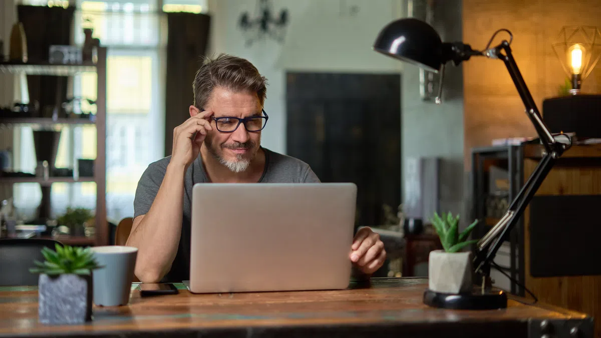 a man sitting at a desk with a laptop