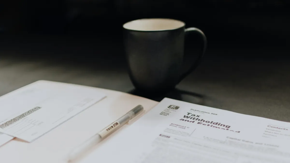 a cup of coffee and a pen on a table